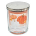 Glass candle with a silver lid and pumpkin-themed label on a white background