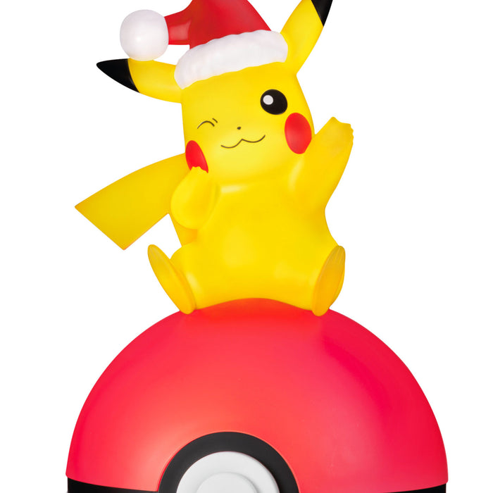 Yellow Pikachu character with a Santa hat on top of a red ball on a white background
