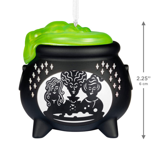 Decorative cauldron ornament with three figures and a green lid on a white background