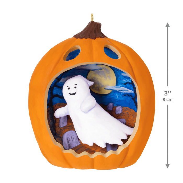Halloween ornament shaped like a pumpkin with a ghost inside, on a white background.