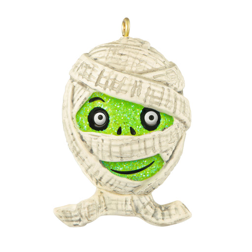 Decorative ornament shaped like a mummy with a green face on a white background