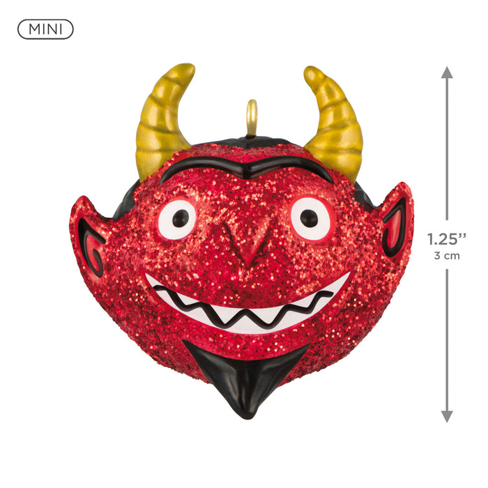Red glittery devil ornament with gold horns and measurement details on a white background
