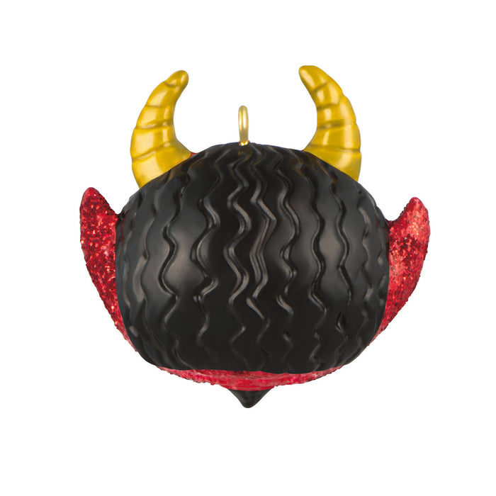 Decorative ornament with black ball, red wings, and yellow horns on a white background