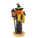 Halloween-themed ornament with a pumpkin face, lantern, and broom on a white background