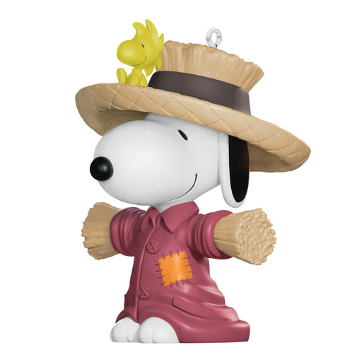 Snoopy figurine in a scarecrow costume with Woodstock on top, on a white background