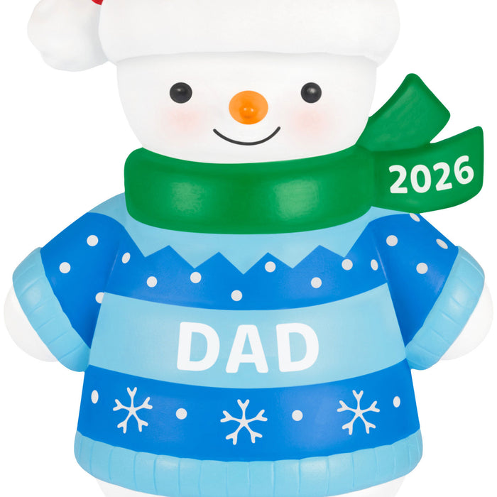 Snowman ornament with a blue sweater labeled 'DAD' and green scarf with '2026' on a white background