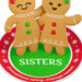 Two gingerbread cookies with the word 'SISTERS' on a decorative background
