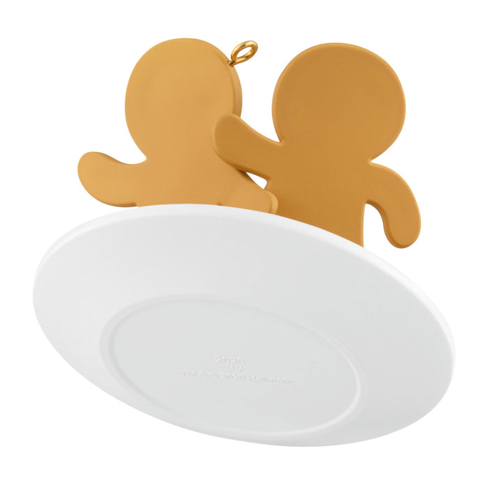 Two gingerbread men on a white circular base