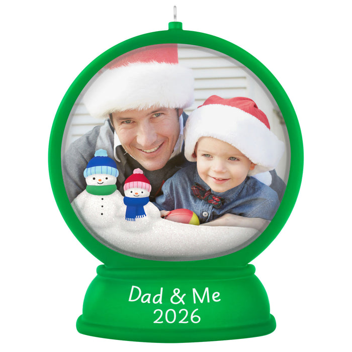 Personalized Christmas ornament with a photo of a man and child wearing Santa hats, surrounded by snowmen, with 'Dad & Me 2026' text.