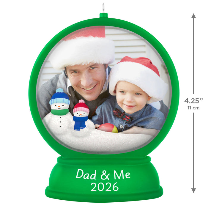 Personalized Christmas ornament with a photo of a man and child wearing Santa hats, surrounded by snowmen, with 'Dad & Me 2026' text.