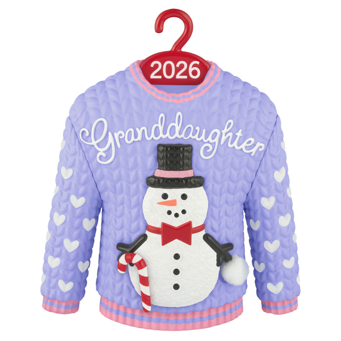 Purple sweater with snowman design and 'Granddaughter' text on a hanger with '2026' label.