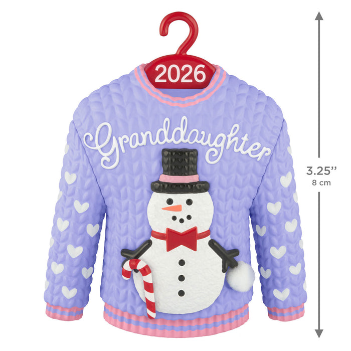 Christmas sweater with a snowman design and 'Granddaughter' text, on a hanger with '2026' label.