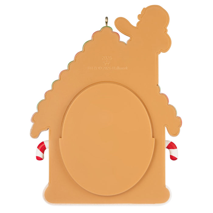 Decorative gingerbread house-shaped cut out with candy cane accents on a white background