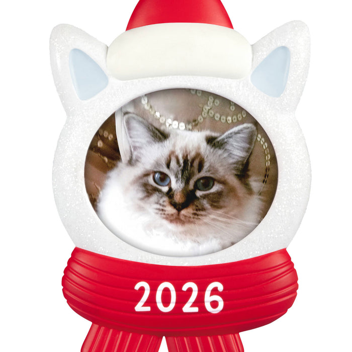 Cat-shaped Christmas ornament with a picture of a cat, red scarf, and Santa hat labeled '2026' on a white background