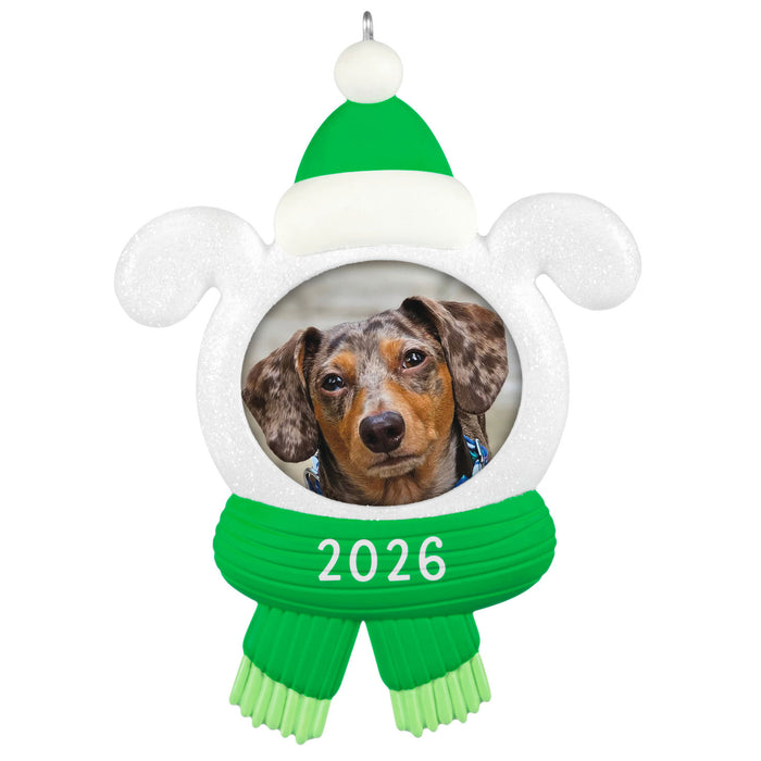 Decorative ornament with a dog photo, green hat, and scarf with '2026' on a white background