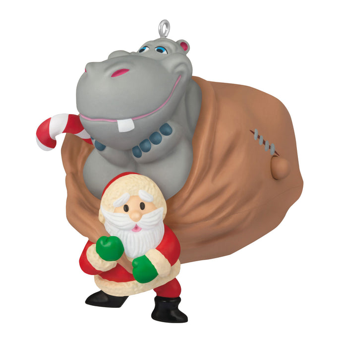 Hippopotamus with a Santa Claus figure and candy cane on a white background