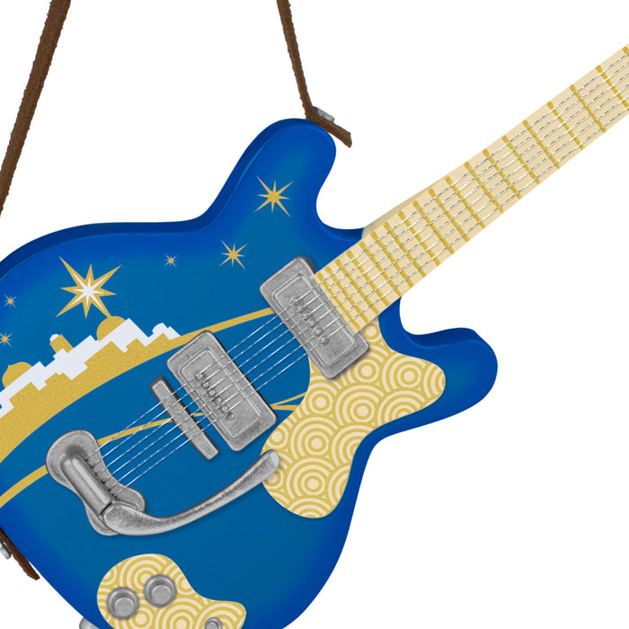 Blue and yellow electric guitar ornament with star and mountain design on a white background