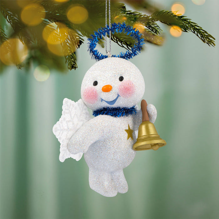 Decorative snowman ornament with a bell and star, hanging on a Christmas tree.