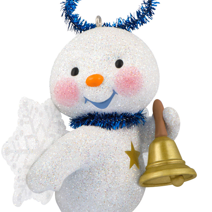 Sparkly snowman ornament with a bell and blue tinsel on a white background