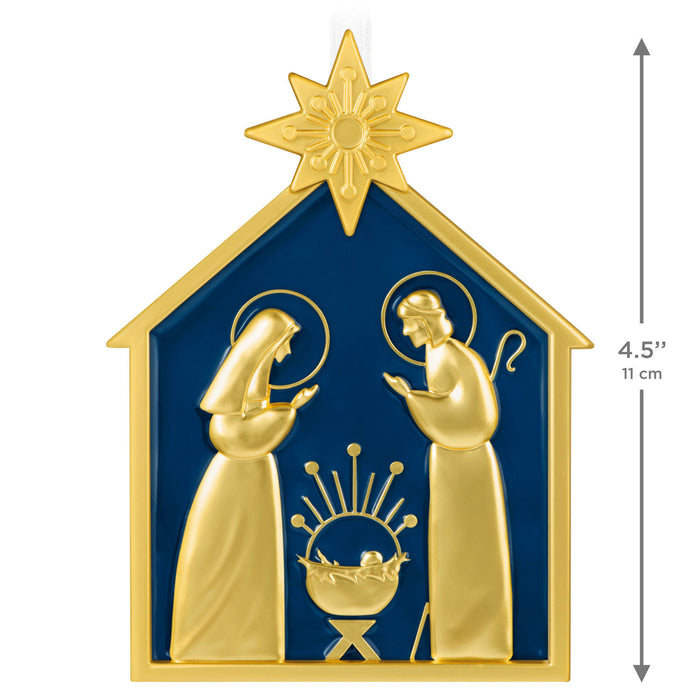 Decorative nativity scene ornament with gold figures on a blue background, featuring a star above.