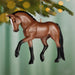 Brown horse ornament hanging on a Christmas tree with blurred lights in the background
