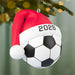 Soccer ball Christmas ornament with Santa hat and '2026' on a blurred Christmas tree background