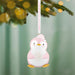 Pink penguin ornament with 'Baby's First Christmas 2026' text on a blurred green background