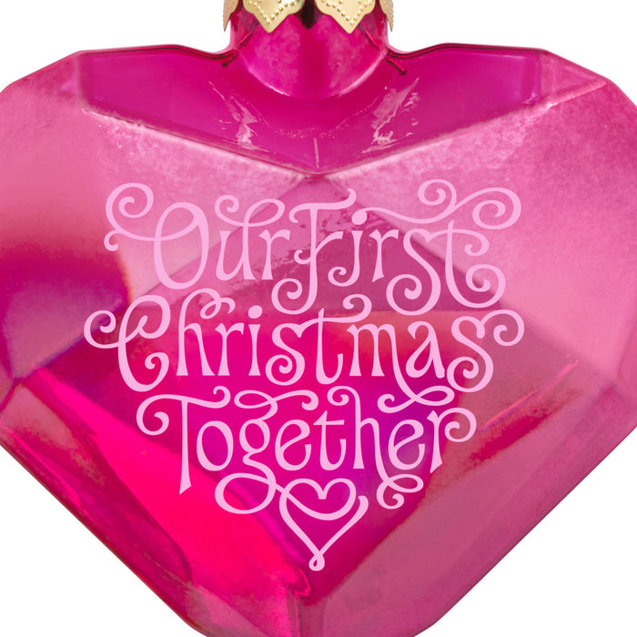 Pink heart-shaped object with 'Our First Christmas Together' text on a white background