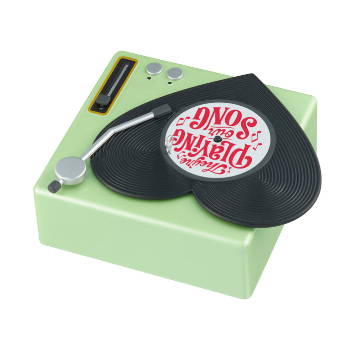 Toy record player with a green base and black turntable, featuring a red and white label.