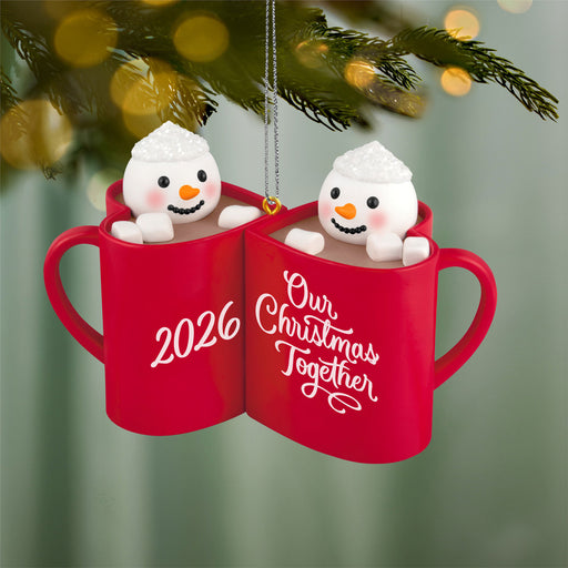 Red mugs with snowmen inside, labeled '2026' and 'Our Christmas Together', hanging on a Christmas tree.