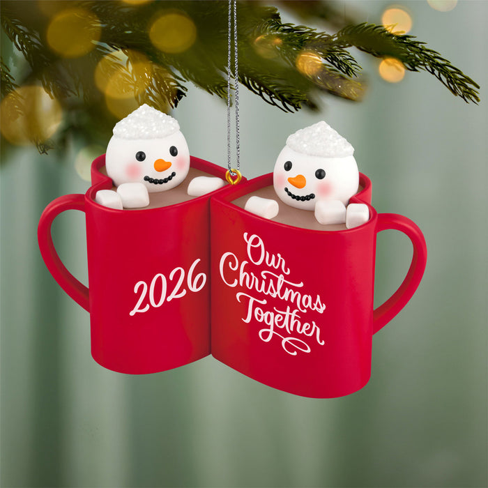 Red mugs with snowmen inside, labeled '2026' and 'Our Christmas Together', hanging on a Christmas tree.