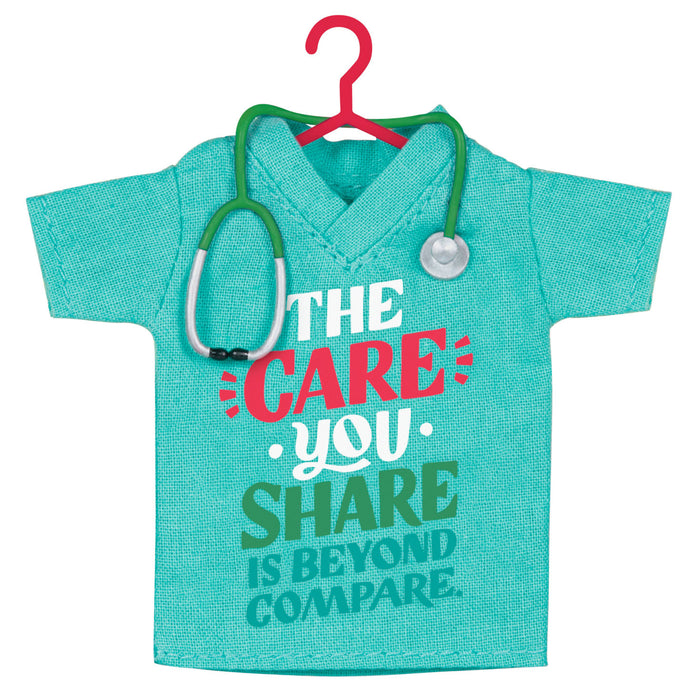 Turquoise scrub top with stethoscope on a red hanger against a white background