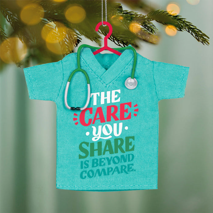 Decorative ornament shaped like a turquoise shirt with a stethoscope, featuring text on a blurred green background.
