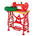Red vintage-style sewing machine with green material on a white background