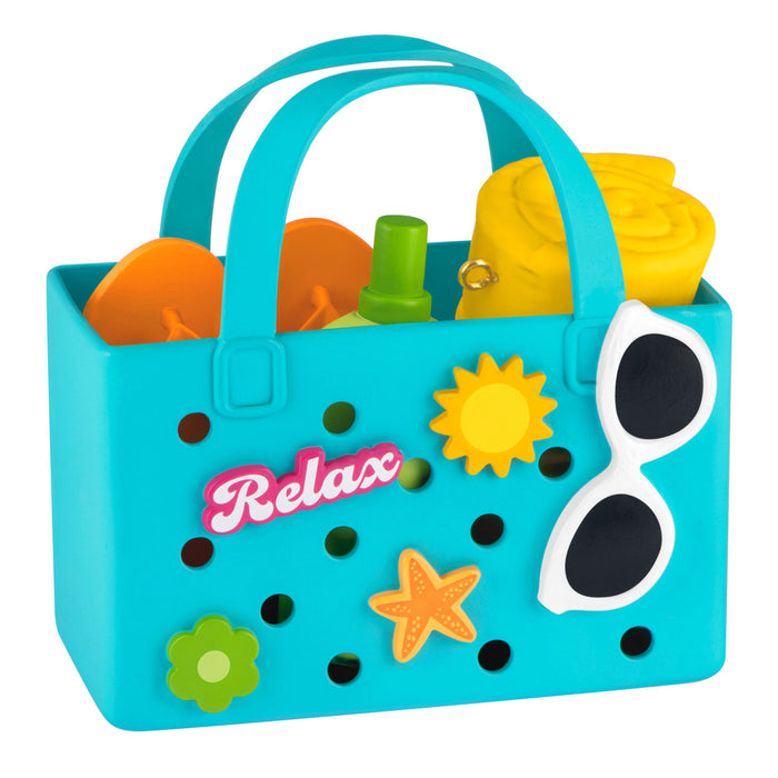 Toy sandcastle set in a blue tote with 'Relax' text and beach-themed decorations on a white background.
