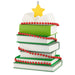 Decorative Christmas tree made of books with a yellow star on top, on a white background.