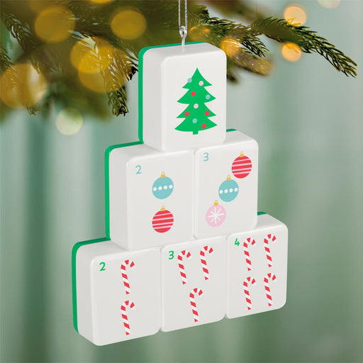 Stack of Christmas-themed blocks with tree, ornaments, and candy cane designs on a blurred green background.