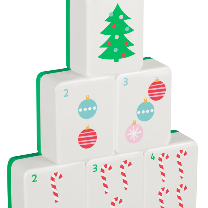 Stack of Christmas-themed dice with tree, ornaments, and candy cane designs on a white background.