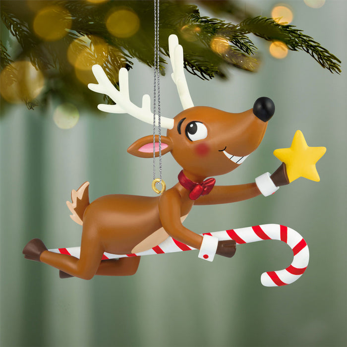 Christmas reindeer ornament with candy cane and star, hanging from a tree.
