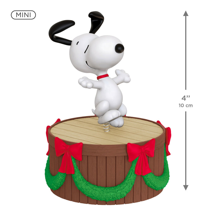 Snoopy figurine on a wooden barrel with red bows and green garland, mini size, on a white background.