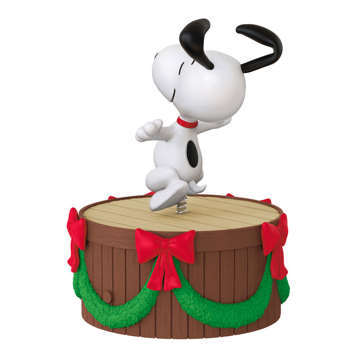 Snoopy figurine on a decorated barrel with red bows and green garlands on a white background