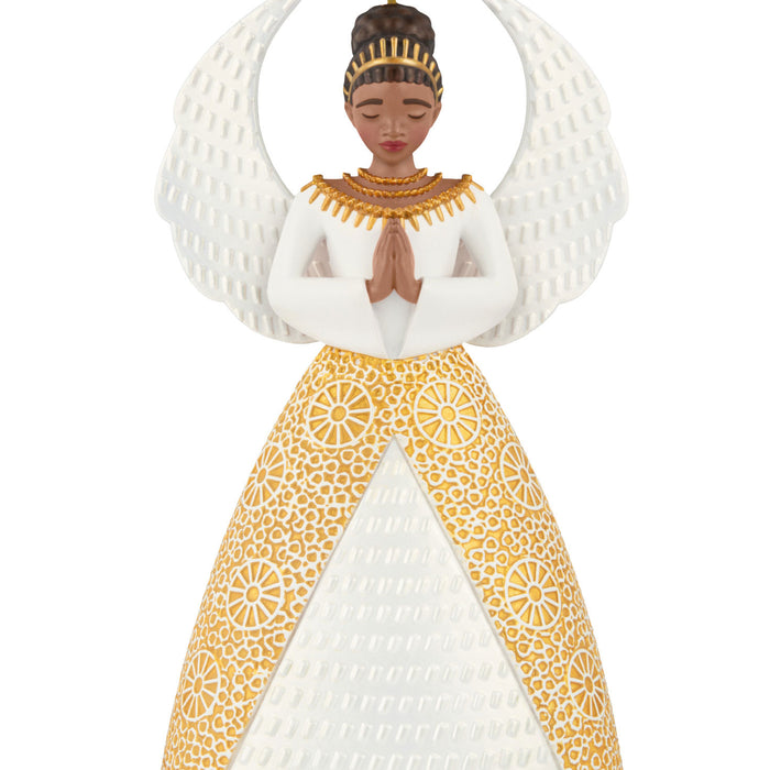 Decorative ornament of an angel in a white and gold dress with a patterned headpiece on a white background