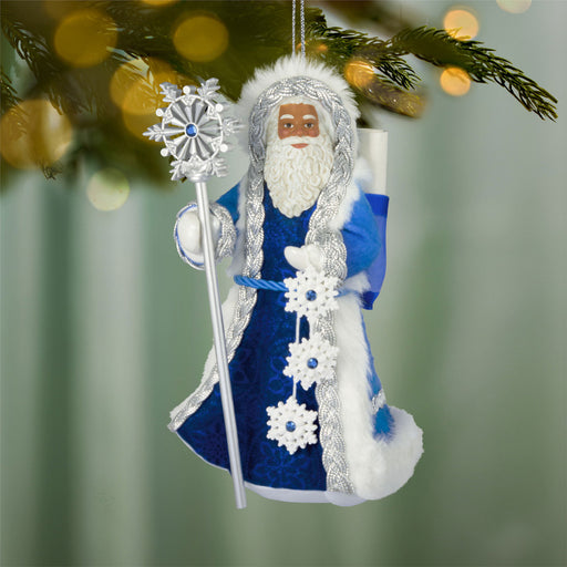 Decorative Christmas ornament of a character in blue and white attire with a staff, hanging on a tree.