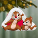 Christmas ornament featuring two animated characters on a green background with blurred lights