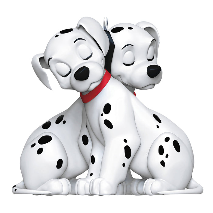 Two Dalmatian dog figurines sitting together on a white background