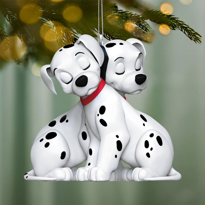 Two Dalmatian dog ornaments hanging on a Christmas tree.