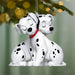 Two Dalmatian dog ornaments hanging on a Christmas tree.