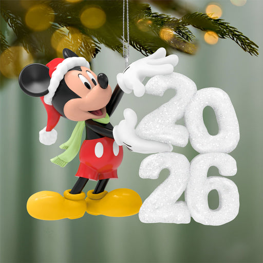 Mickey Mouse Christmas ornament with '2026' on a blurred green background
