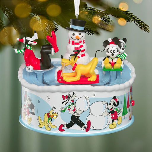 Decorative Christmas ornament with animated characters on a rotating platform.