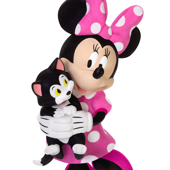 Plush toy of a character with a large pink bow holding a black and white cat plush toy on a white background